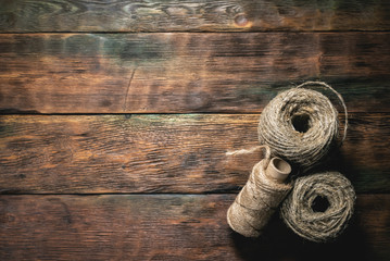 Skeins of jute rope on wooden table flat lay background with copy space.