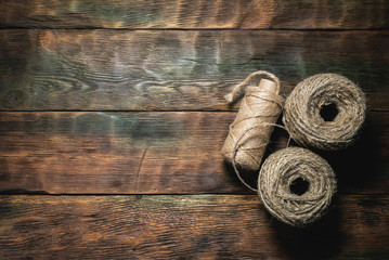 Skeins of jute rope on wooden table flat lay background with copy space.