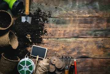 Soil in the flower pots and gardening tools on wooden flat lay background with copy space.