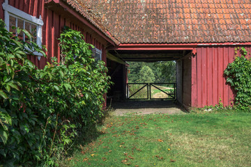 Fototapeta na wymiar Traditional red farm buildings and gate in Skane, Sweden