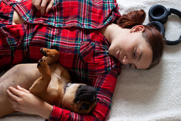 French Bulldog with young woman smiling while lying on the floor at home