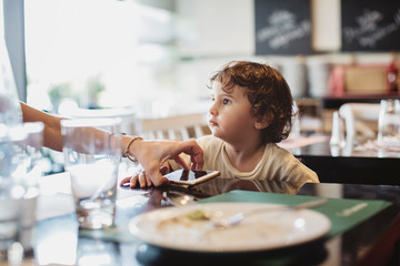 Mother take a smart phone from her 2 year old son