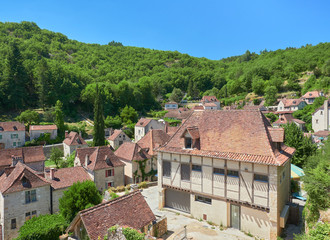 Fototapeta na wymiar Landscape view of the typical houses and roofs of Saint-Cirq-Lapopie, one of the most beautiful villages in France (Plus Beaux Villages de France), Lot River valley, Causses du Quercy Natural Park