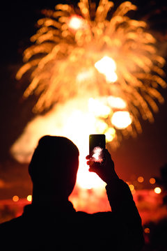 Man photographing fireworks using smartphone