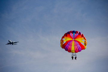beautiful blue sky. paraglider. parachute. plane in the sky. paraglider in the blue sky and a plane