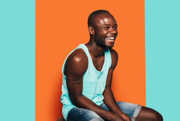 Happy young black man laughing away with summer outfit