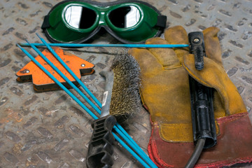 welding machine, in the workshop, welding mask, leather gloves, welding electrodes, high-voltage wires with clips, a set of accessories for arc welding.