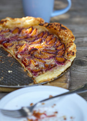 Almond plum cake on puff pastry. Delicious summer breakfast.