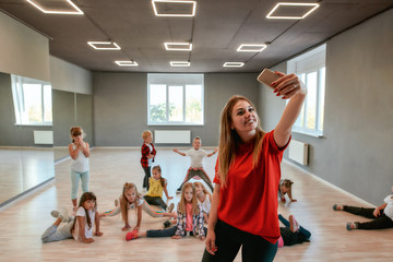 Happiness is Dancing . Young and positive dance teacher making a selfie with children while having choreography class