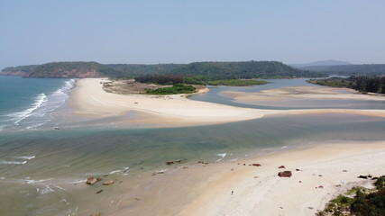 river flowing into the ocean with waves and a sandy beach
