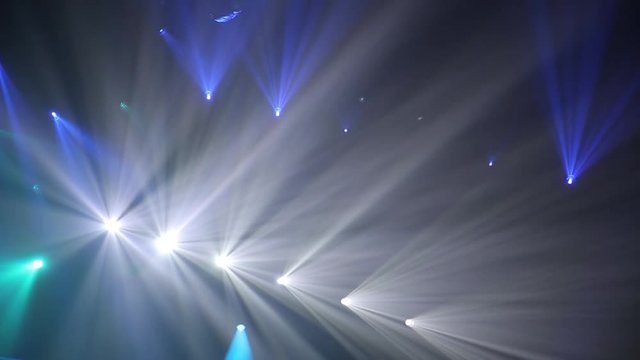 Blue Stage Ray Of Light In Concert Hall. Lighting lamp rays shiny dynamic effect. Laser lights on the stage.  Professional lighting and show effects.