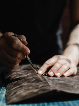 Close up of a leather and hands of a craftsman. Detail of a handmade process