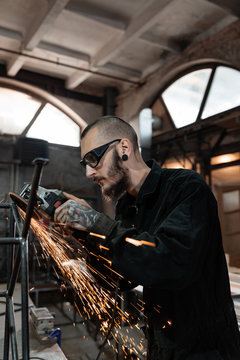 Metalworker grinding iron framework