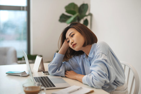 Bored Millennial Female Worker Lie At Office Desk Look At Laptop Screen Think About Problem Solution