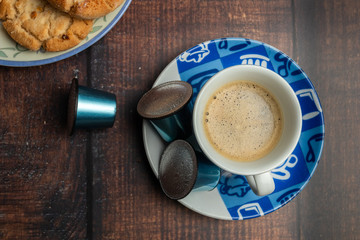 Taza de café con galletas y cápsulas