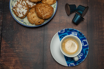 Taza de café con galletas y cápsulas