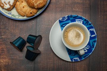 Taza de café con galletas y cápsulas