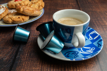 Taza de café con galletas y cápsulas