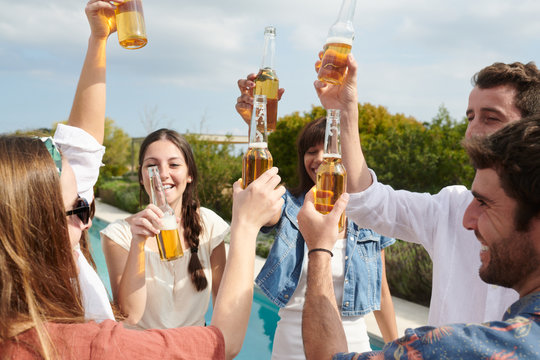 Happy friends raising drinks for fun.