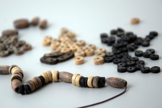 Close-up of African wooden beads on white surface, depth of field