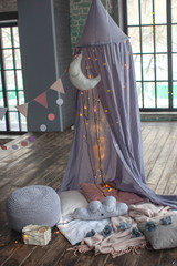 Background with a play tent. For girl. Birthday and family photo shoot. Light bulbs and highlights. Pillows and decor. Blurred background.  © Юлия Ефимова