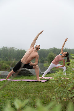 Sportive couple training on green meadow