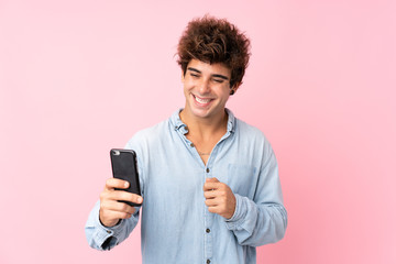 Young caucasian man with jean shirt over isolated pink background making a selfie