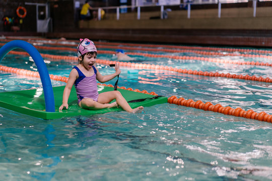 Little Girl Swimming In A Indoor Pool.