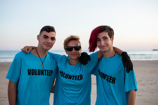 three people hugging during a volunteer beach clean