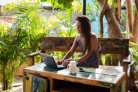 Female digital nomad at work with her laptop, outdoor in fresh air