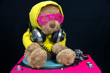 brown teddy bear dj in yellow hoodie on turntables