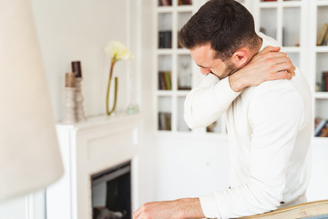 Male touching his neck with his hand