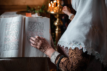 Old Lady's Hand Resting On An Open Bible