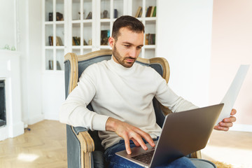 Male with a document sitting in an armchair