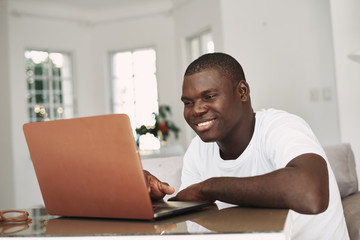 man of african appearance in front of a laptop