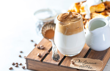 Iced frothy drink Dalgona Coffee, trend korean drink latte espresso with coffee. Gray concrete background.