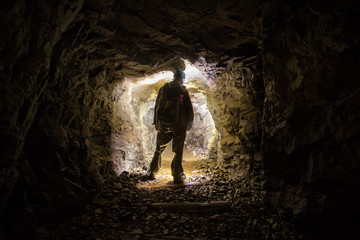Underground abandoned platinum ore mine tunnel with miner