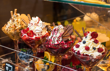 Sweet desserts and ice cream with different toppings and flavours with berries, cookies and fruits
