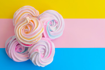 Fototapeta na wymiar rainbow meringue cakes on a multicolored background