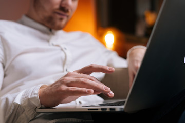 Close-up of man typing on laptop computer keyboard in home. Businessman hands typing on keyboard.