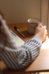 A view of a girl drinking coffee while studying