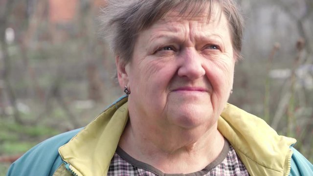 Portrait Of Old Caucasian Woman Smiling Happy Looking At Camera In Garden Background. Real People Series