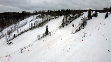 Aerial view of downhill skiing at local ski resort. Ski lift. Russia, Leningrdaskaya oblast, village Korobitsyno near Saint Petersburg.