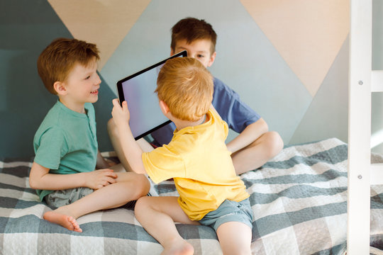 the child pictures of other children on the screen in clothes of blue and yellow home