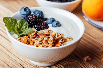 Breakfast bowl with  granola, dried fruits, blackberries, blueberries, yogurt