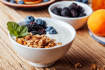 Breakfast bowl with  granola, dried fruits, blackberries, blueberries, yogurt