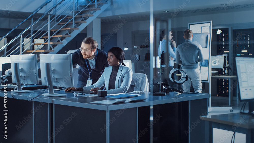 Fototapete Electronics Development Engineer Working on PC, Talks with Project Manager. Team of Professionals Use CAD Software, Machine Learning and Neural Networks for Modern Industiral Engineering Design. 