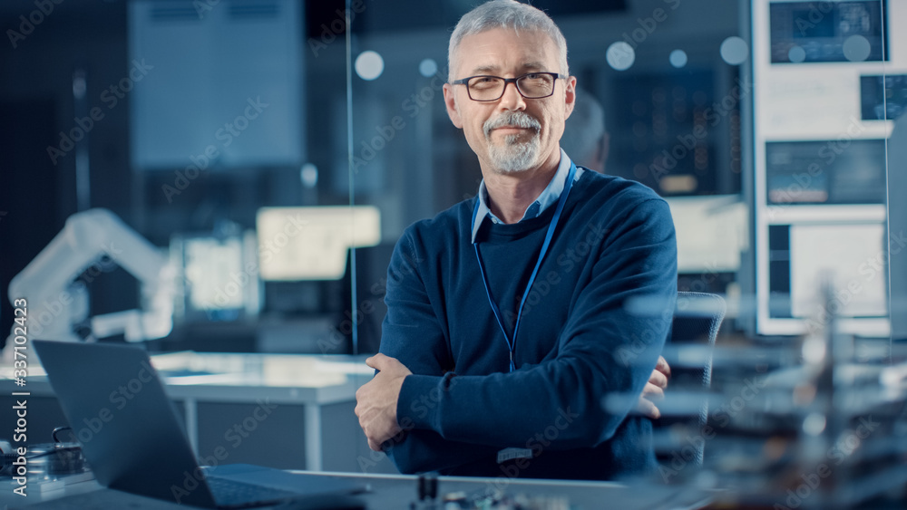 Poster professional electronics design engineer wearing glasses works on laptop computer in research labora