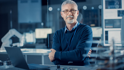 Professional Electronics Design Engineer Wearing Glasses Works on Laptop Computer in Research...