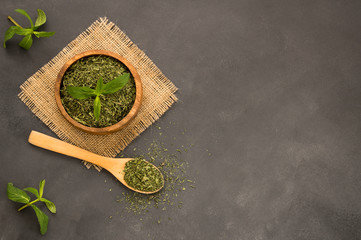 Fresh green peppermint leaves and dried mint leaves in wooden spoon on rustic table. Dry spice concept © mescioglu